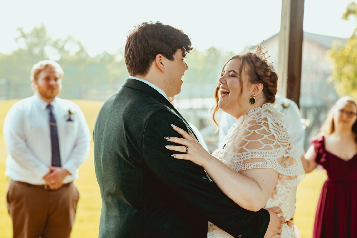 Wedding couples dance together during a joyful reception celebration in warm sunlight.
