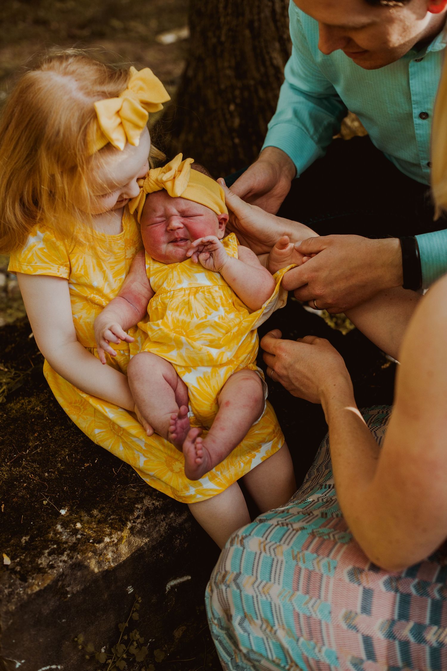 A series of photos showing a person in a turquoise shirt holding a baby wearing a yellow dress outdoors.