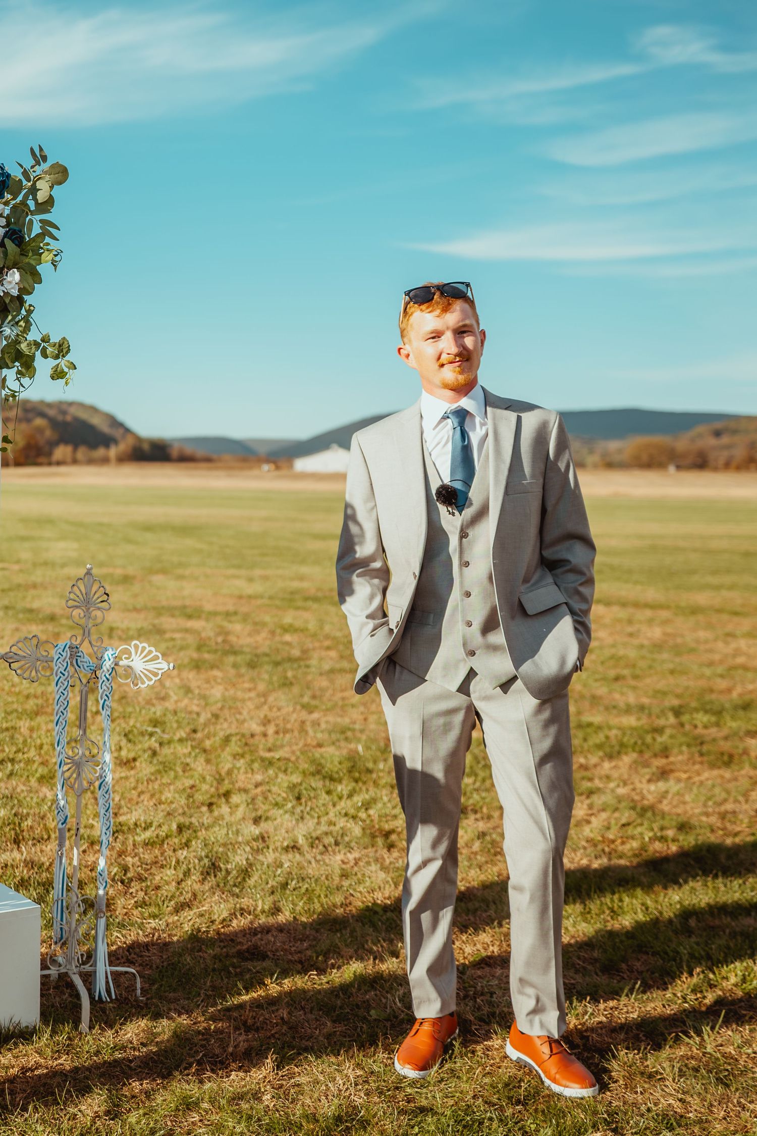Light gray suit with orange shoes photographed in sections against a sunny outdoor field.
