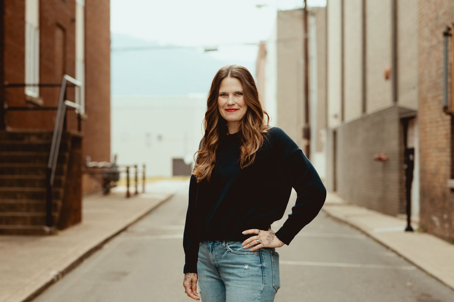 People gathered in a rustic brick alley setting for a casual outdoor photo shoot.