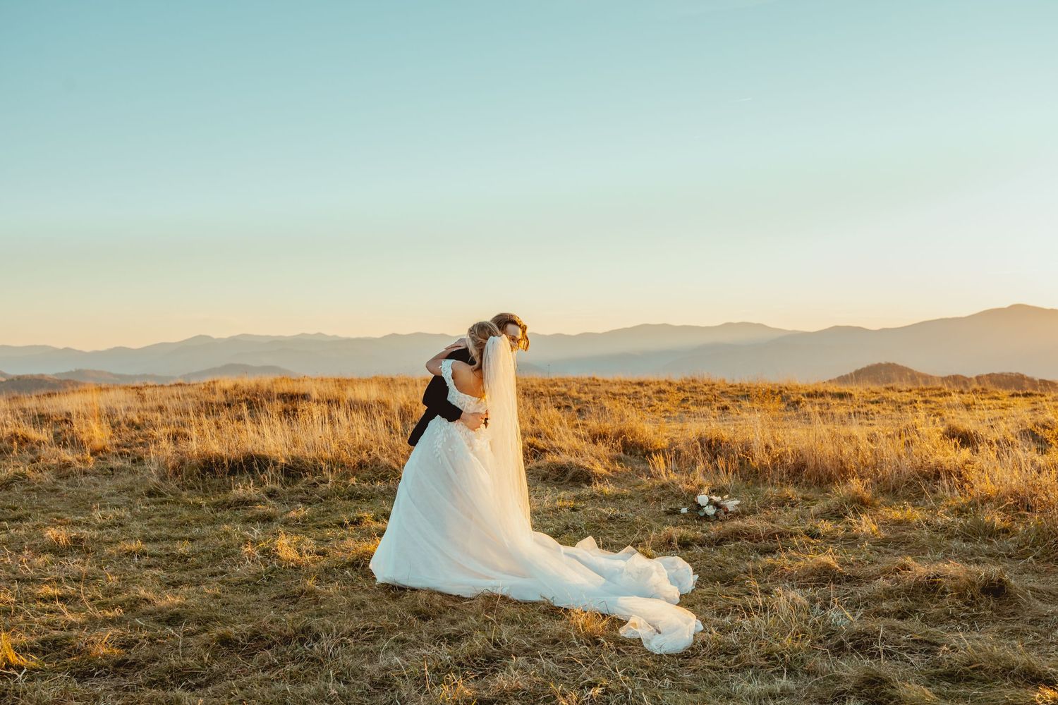 Desert mountain landscape with flowing white wedding dress captured at golden hour.