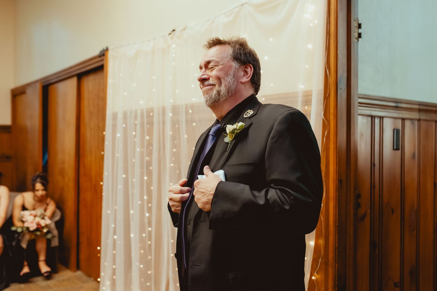 Emotional reactions captured during wedding reception in dimly lit venue with string lights.