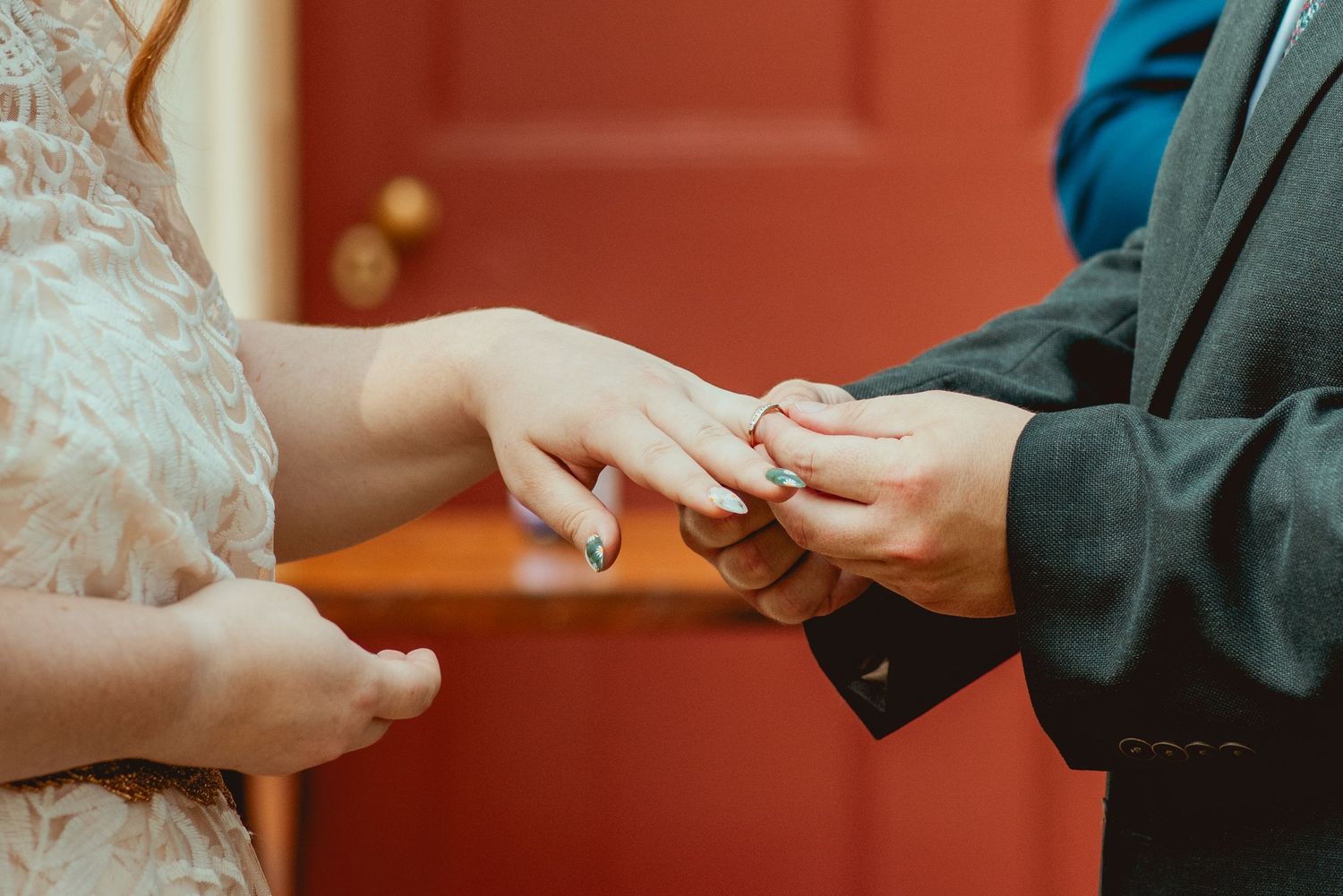 Close-up view of hands exchanging rings during a traditional wedding ceremony.