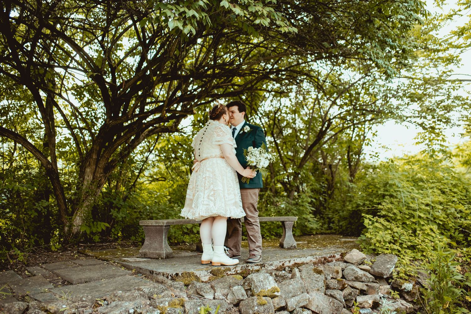 A couple shares a romantic moment in a lush garden setting during their wedding photo session.