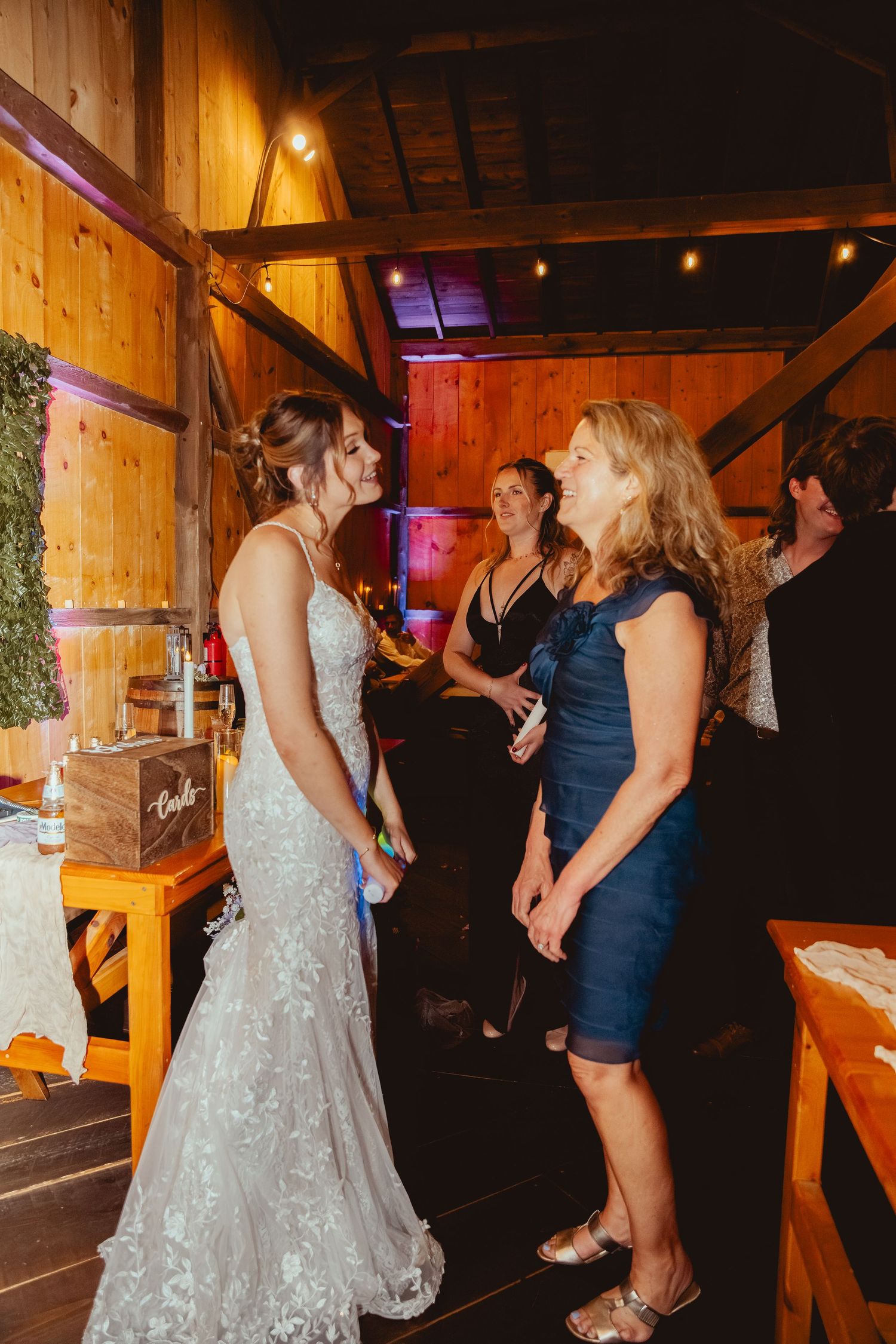 Wedding reception dancing scene in a wooden barn with ambient lighting.