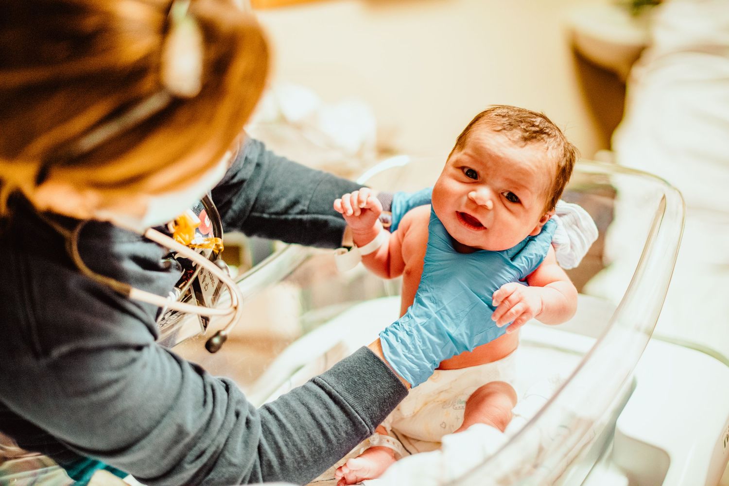 A series of medical professionals examining a newborn baby during routine health checkups.