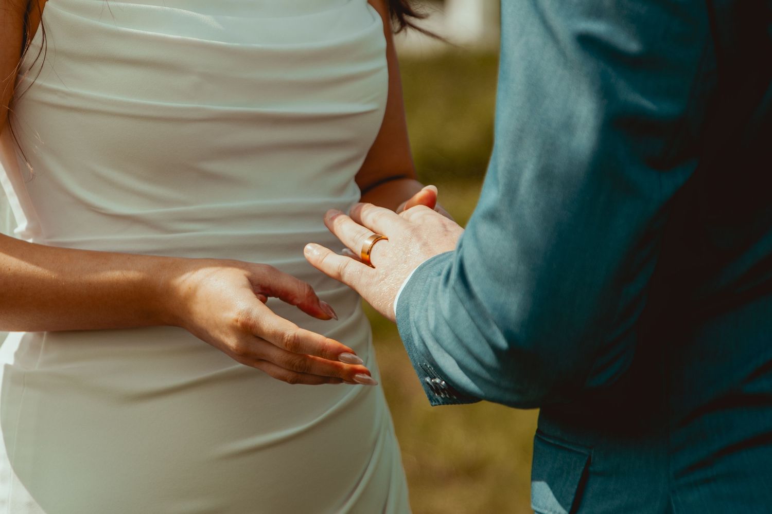 Detail shot of formal wedding attire in white and teal during outdoor celebration.