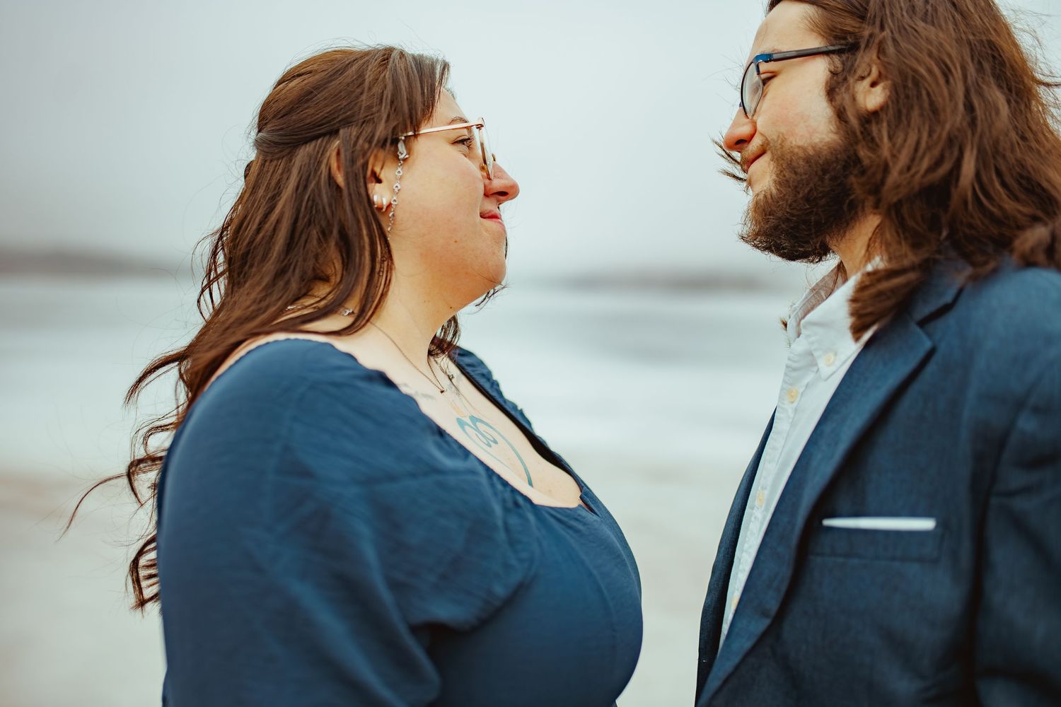 Two people in blue and navy outfits share a joyful moment while standing outdoors.
