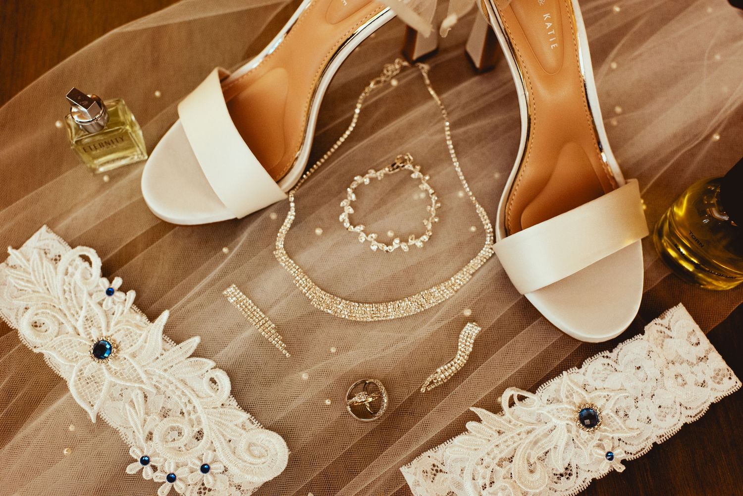 Delicate white lace trim and fabric pieces laid out on a rustic wooden surface in warm lighting.