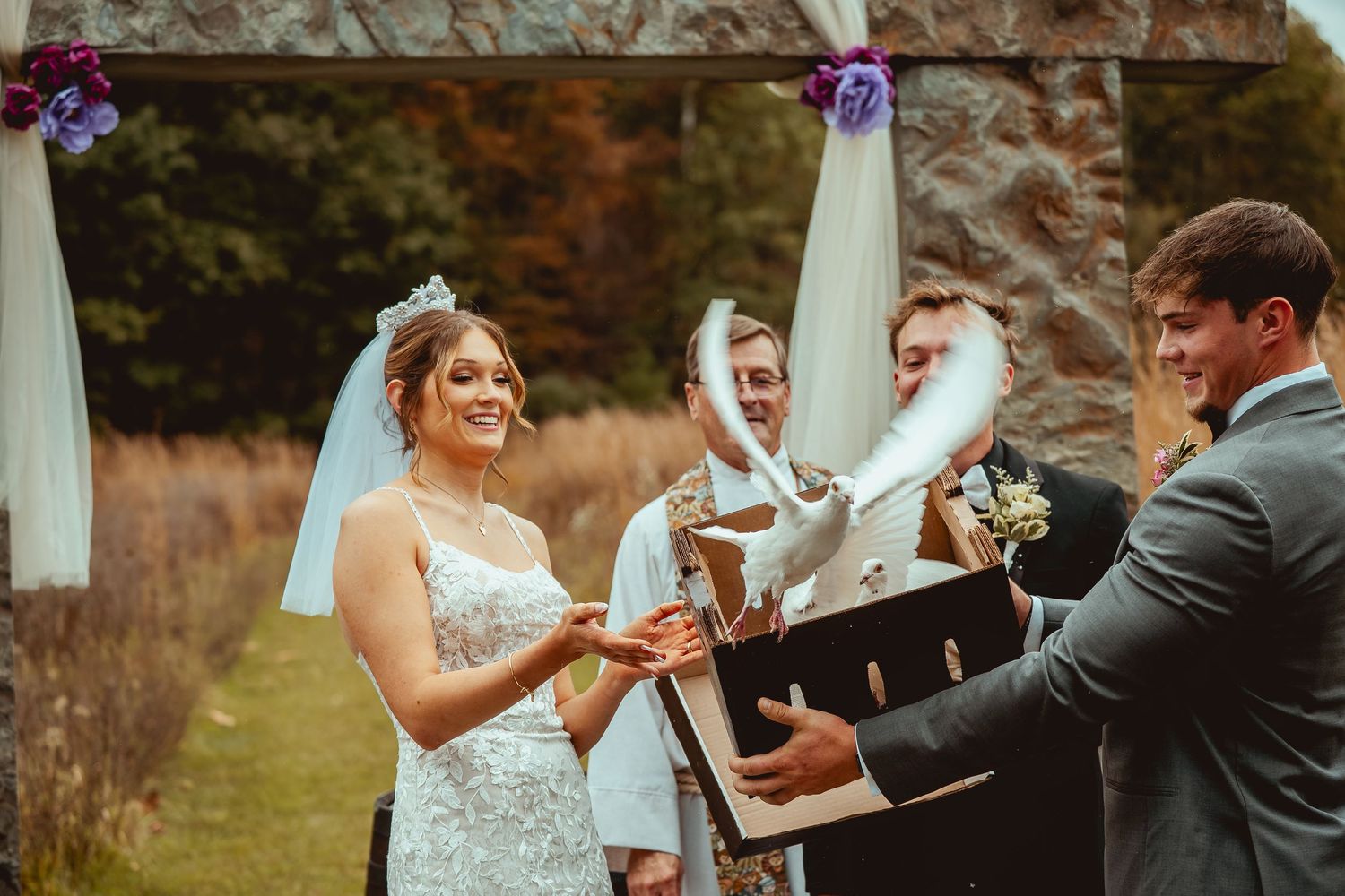 Couple dancing and celebrating during outdoor autumn wedding ceremony.
