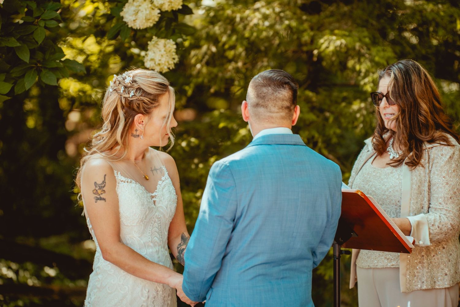 Couple in light blue and white attire sharing intimate moments during outdoor wedding photo session.