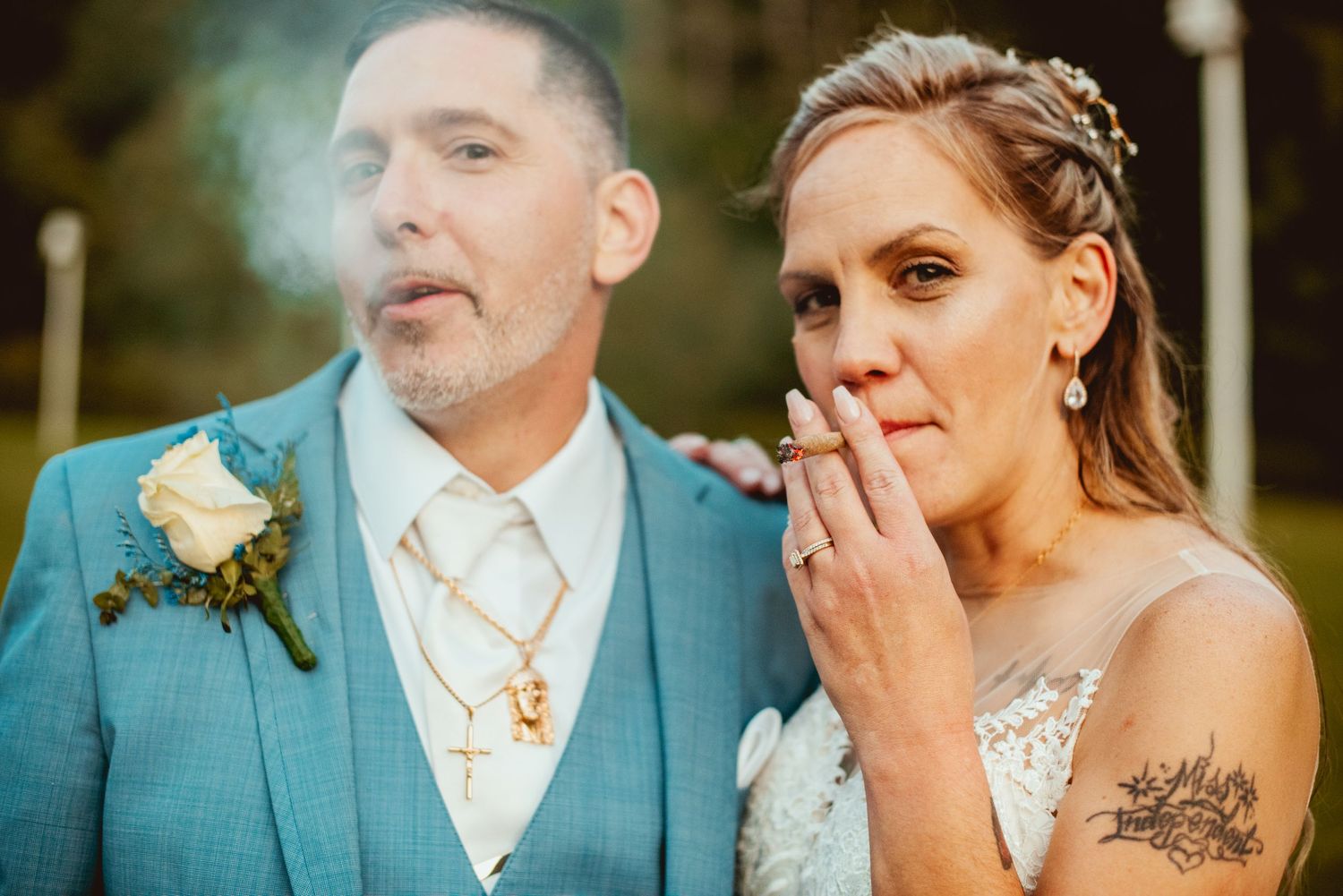 Wedding couple share an emotional moment while cutting their tiered white cake at their reception.