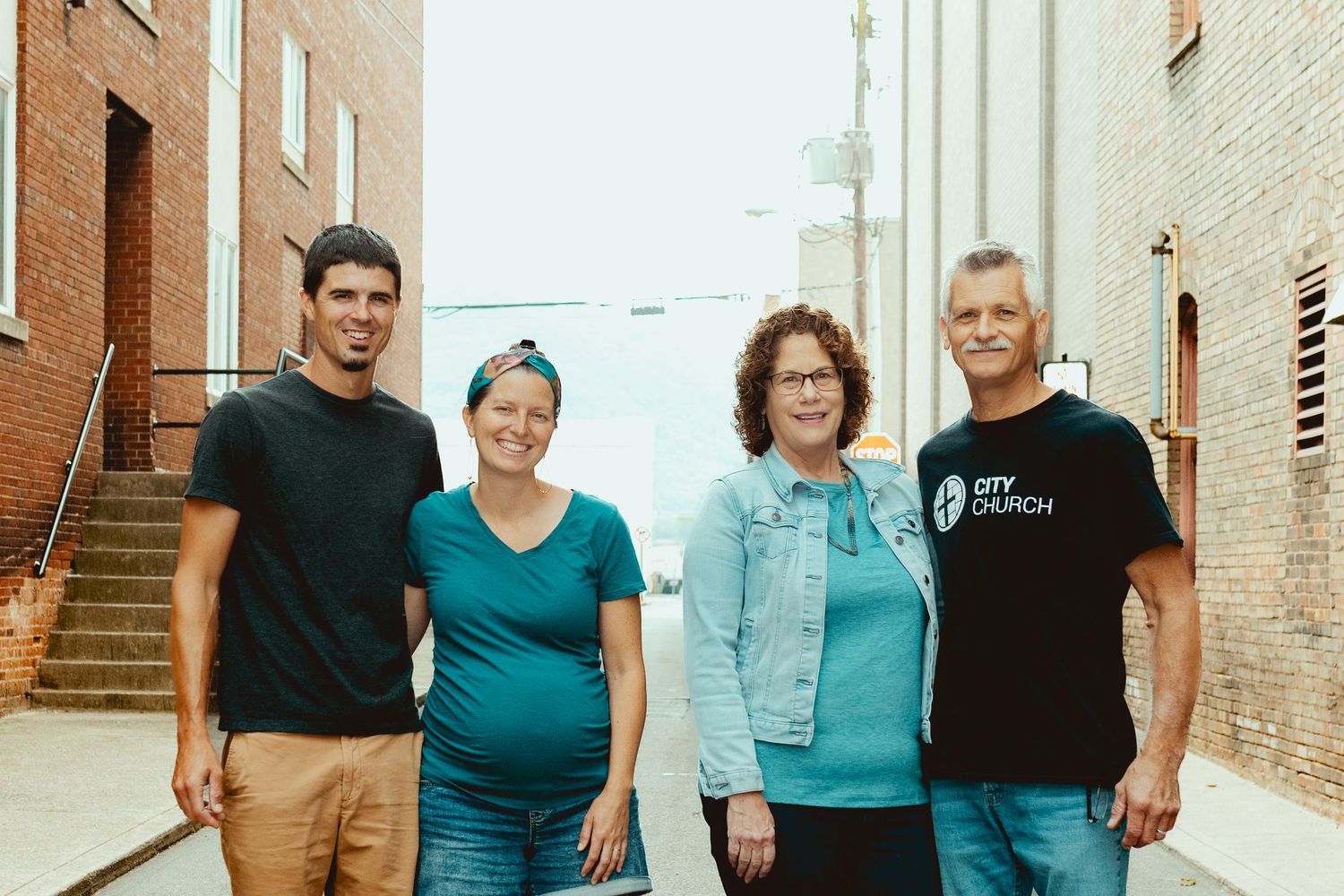 Family group photos captured in an industrial urban setting with brick walls.