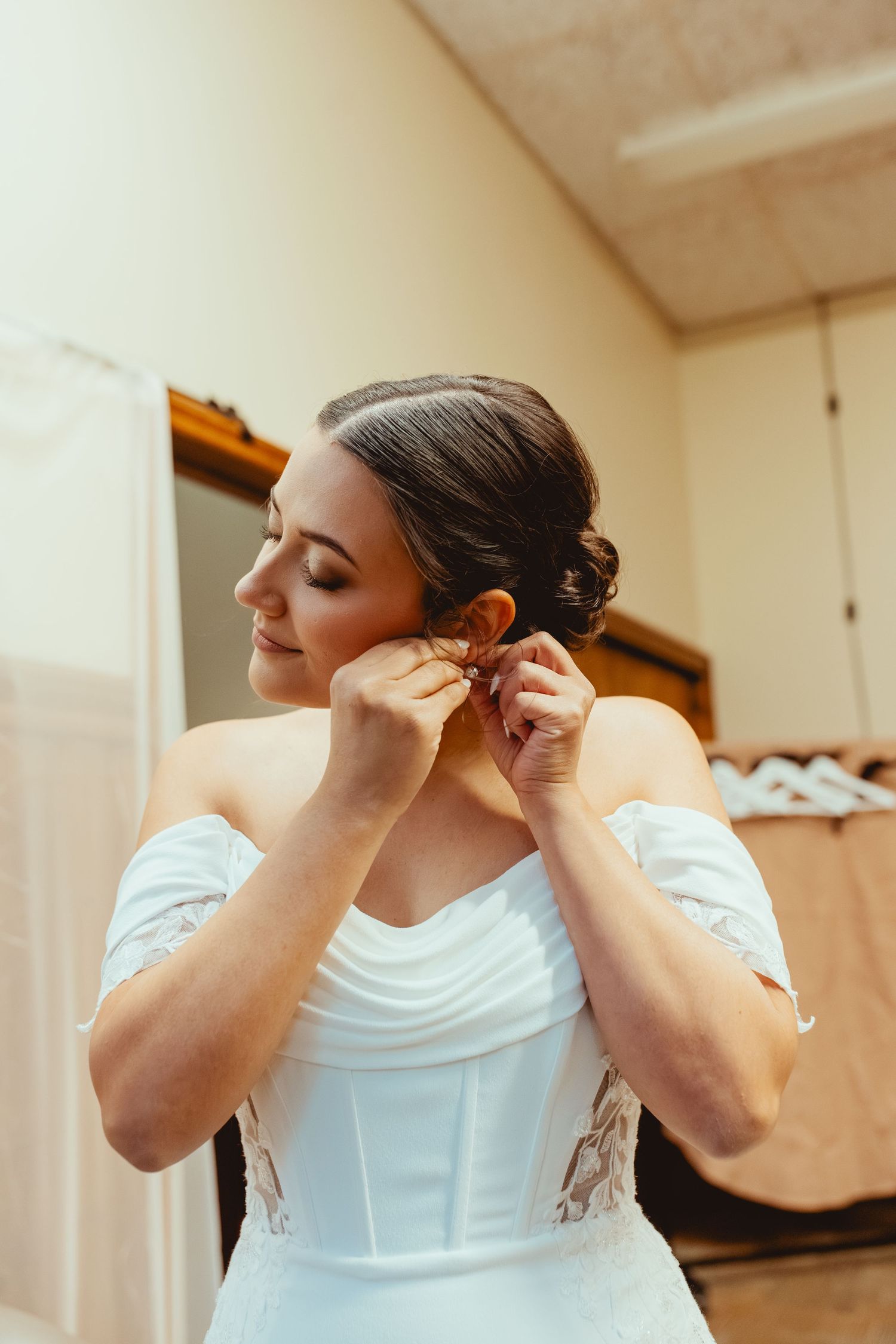 A series of photos showing someone putting on earrings while wearing a white top.