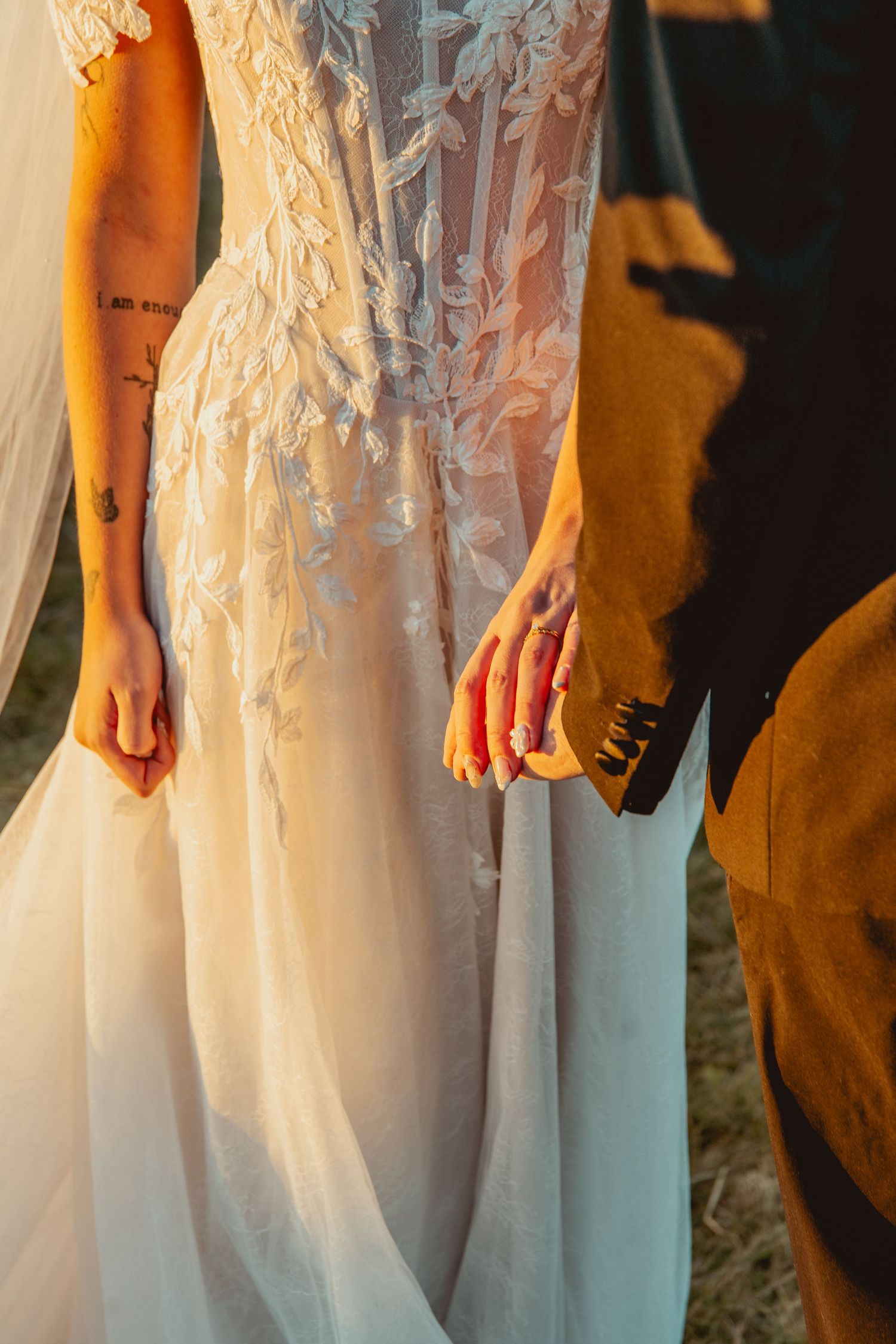 Detail shot of intricate lace wedding dress with delicate embroidery pattern.