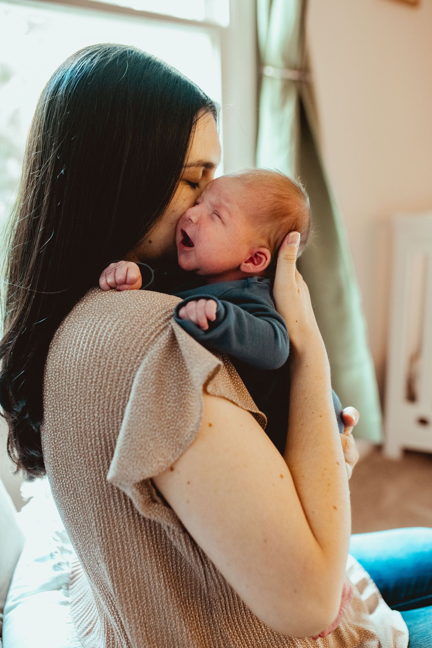 A tender moment between parent and child sharing cuddles and kisses on a bright morning.