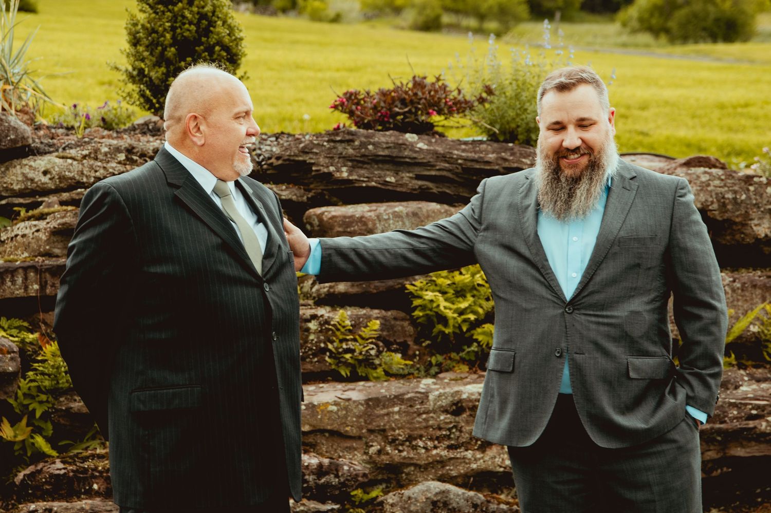 Candid moments between wedding party members sharing laughs in an outdoor setting.