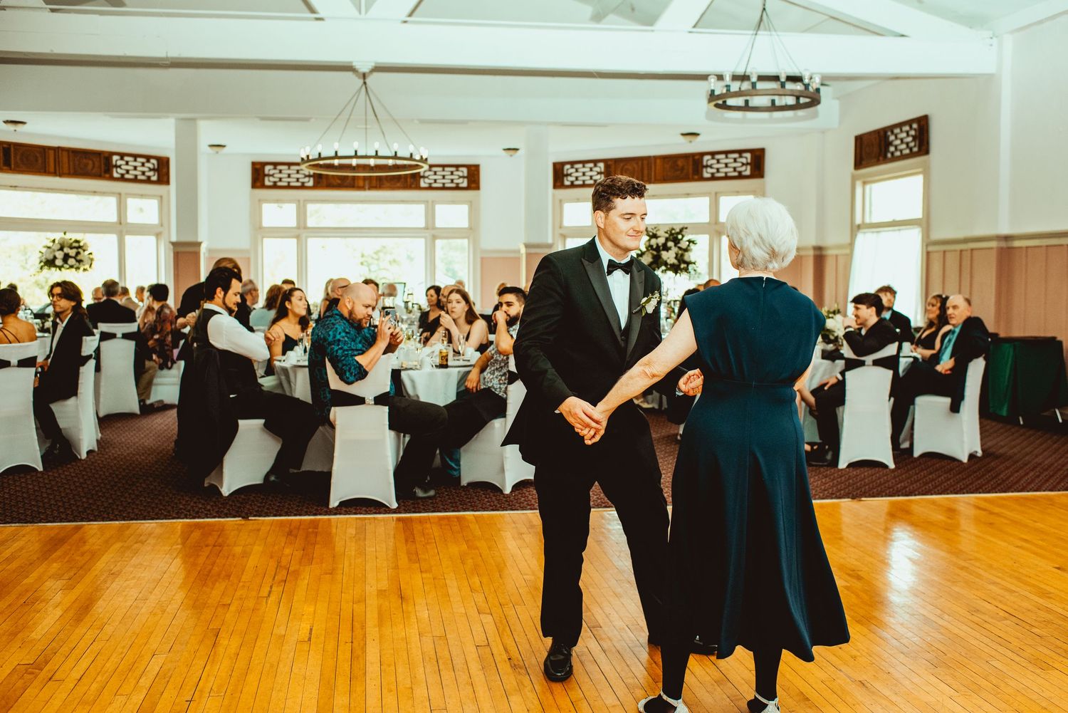 Wedding reception dance floor filled with guests enjoying themselves in a bright indoor venue.