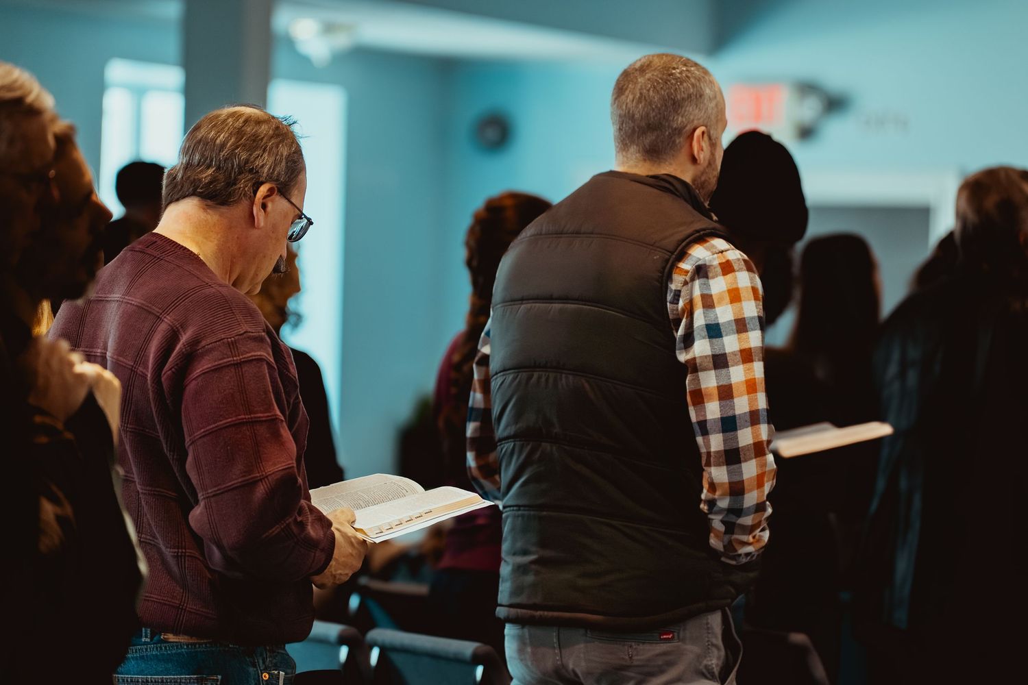 People gather in a church lobby with a blue wall background during a community event.