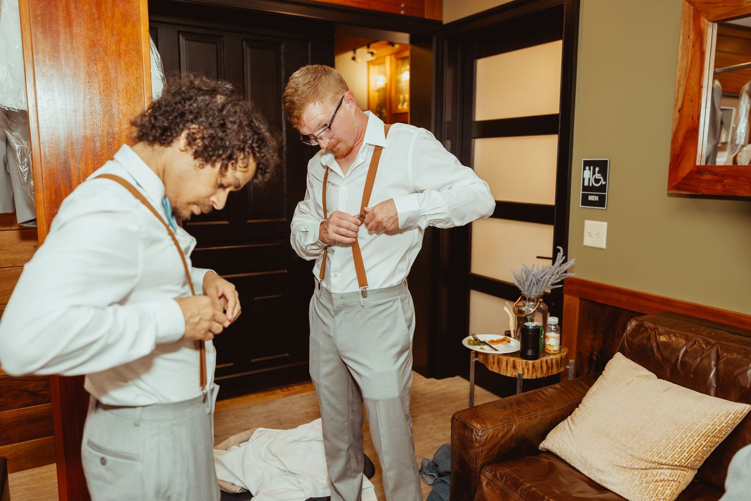 Wedding party getting ready in a rustic indoor setting with warm lighting and wooden decor.