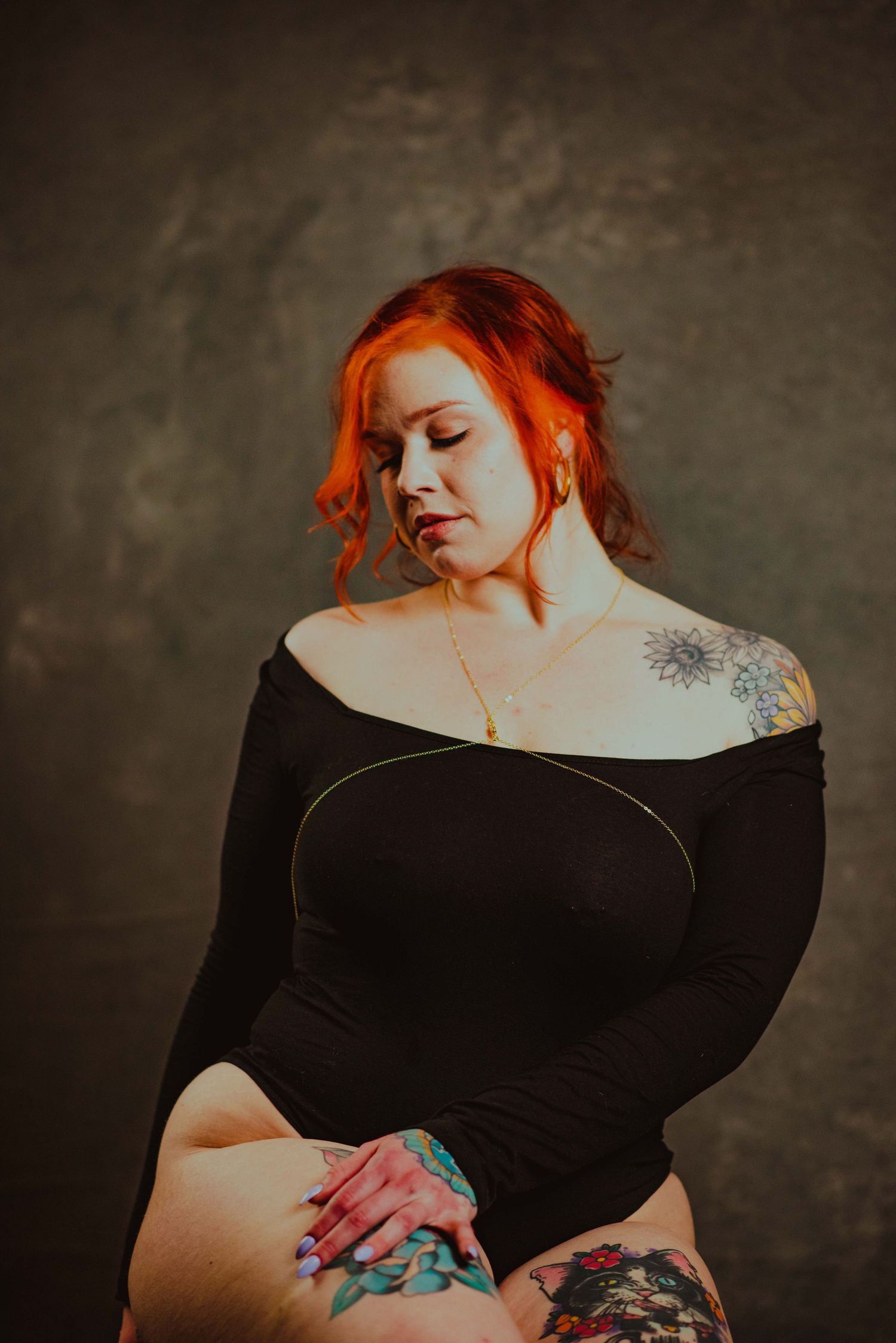 Intimate portrait series with black clothing and dramatic shadows highlighting colorful tattoo artwork.