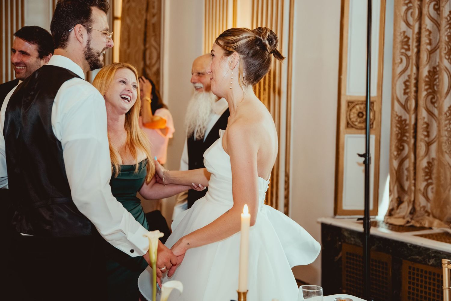 Wedding celebration sequence showing dancing and laughter between guests in an elegant ballroom setting.