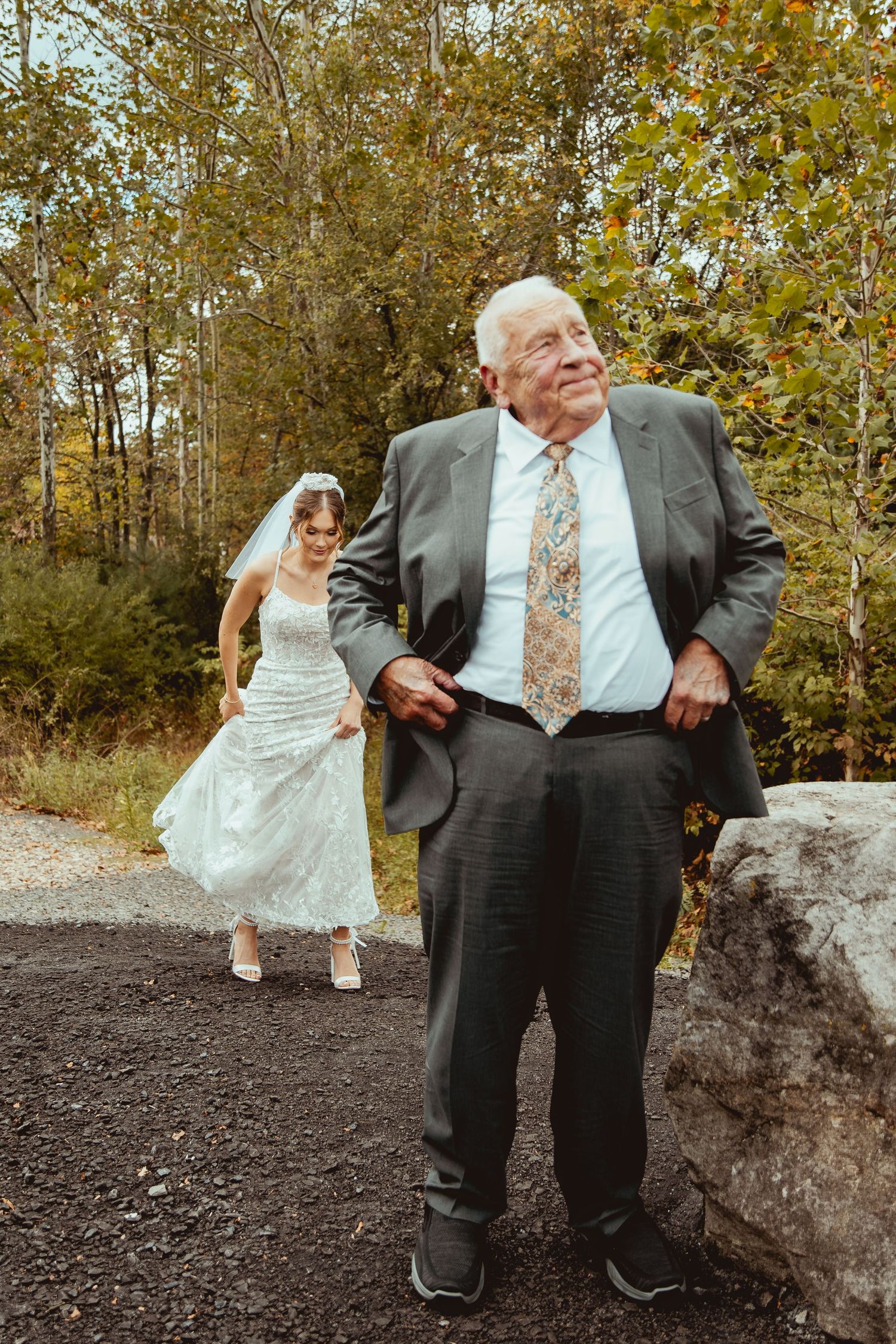 A series of playful poses showing someone in a gray suit and tie leaning against a large rock outdoors.