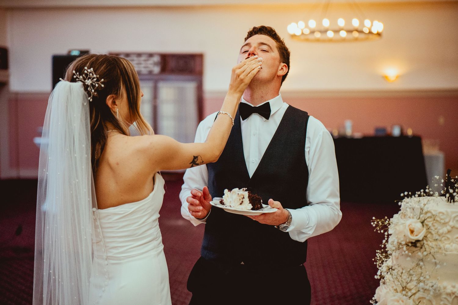 Couples dancing and celebrating at an indoor wedding reception with warm lighting.