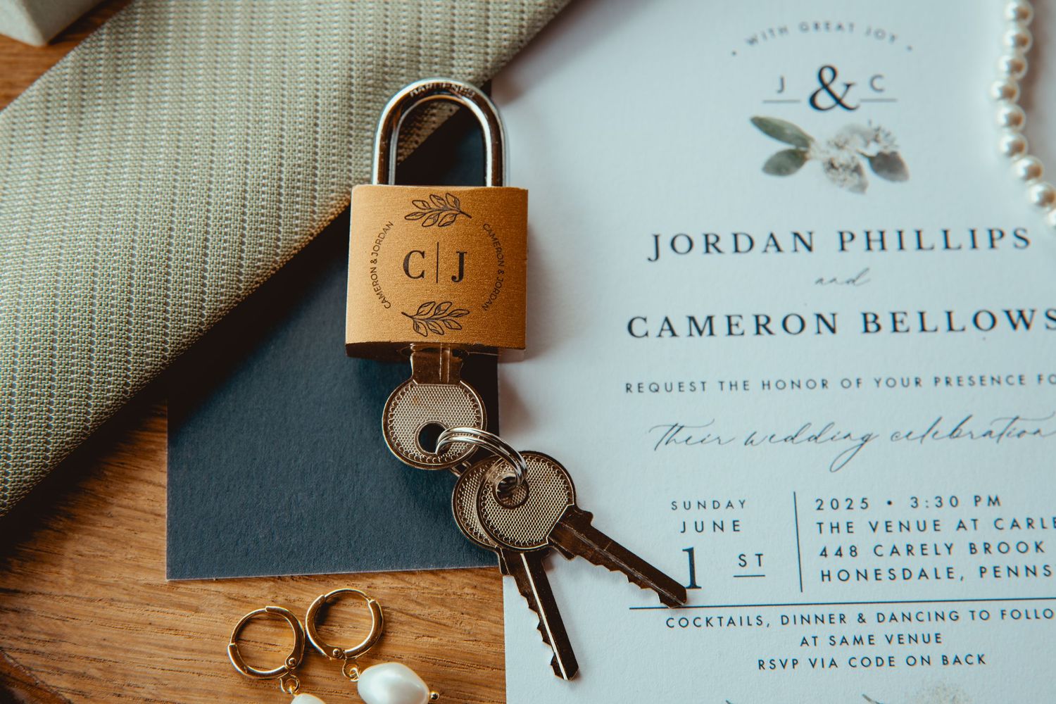 Wedding stationery and rings arranged with vintage locks and natural textures.