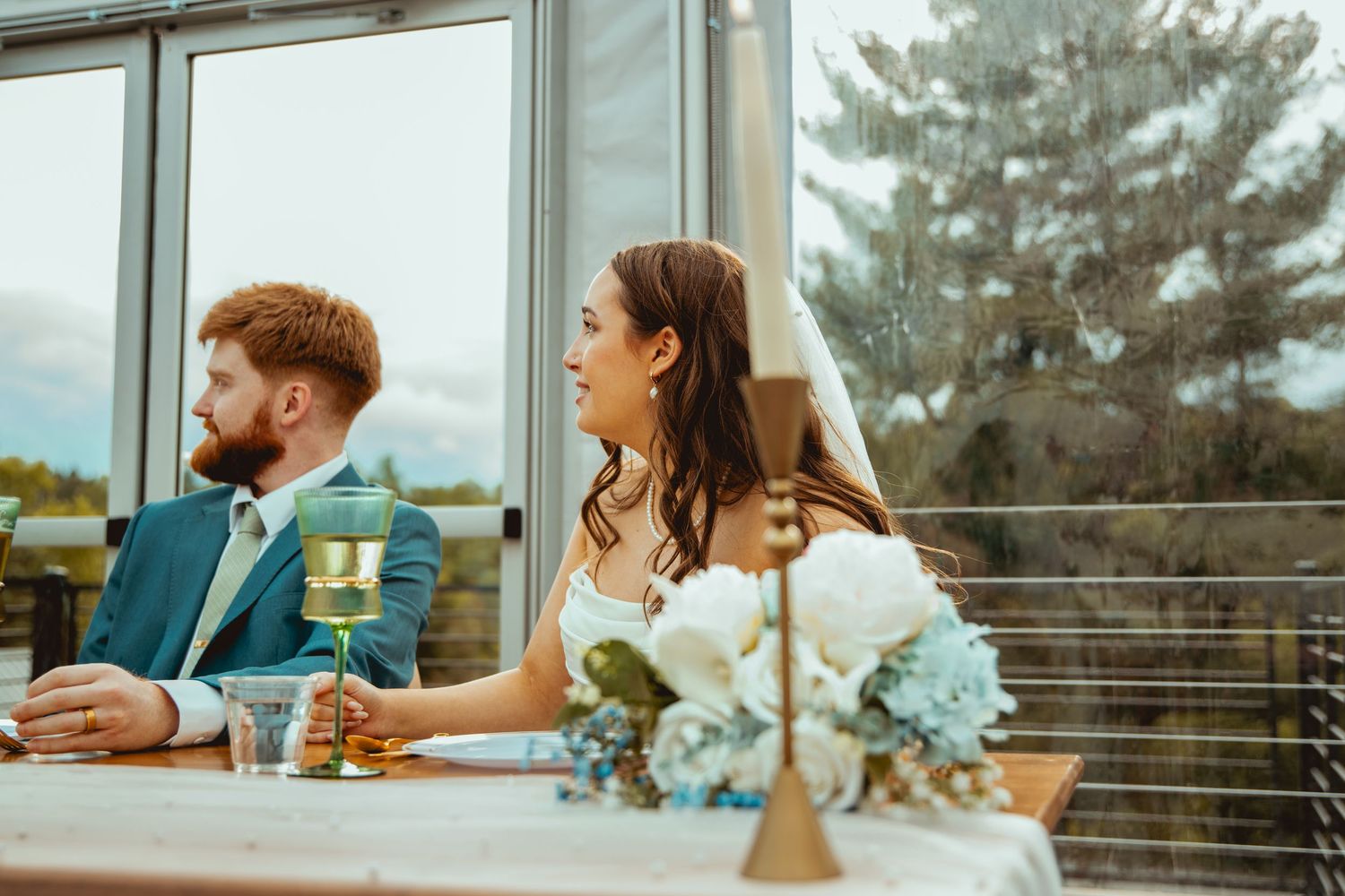 Wedding guests enjoying drinks and conversation on an outdoor patio during sunset.