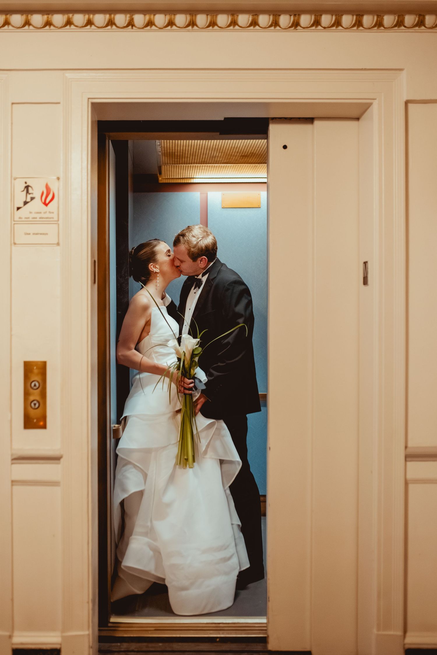 Wedding couple sharing romantic moments in vintage elevator doorways.