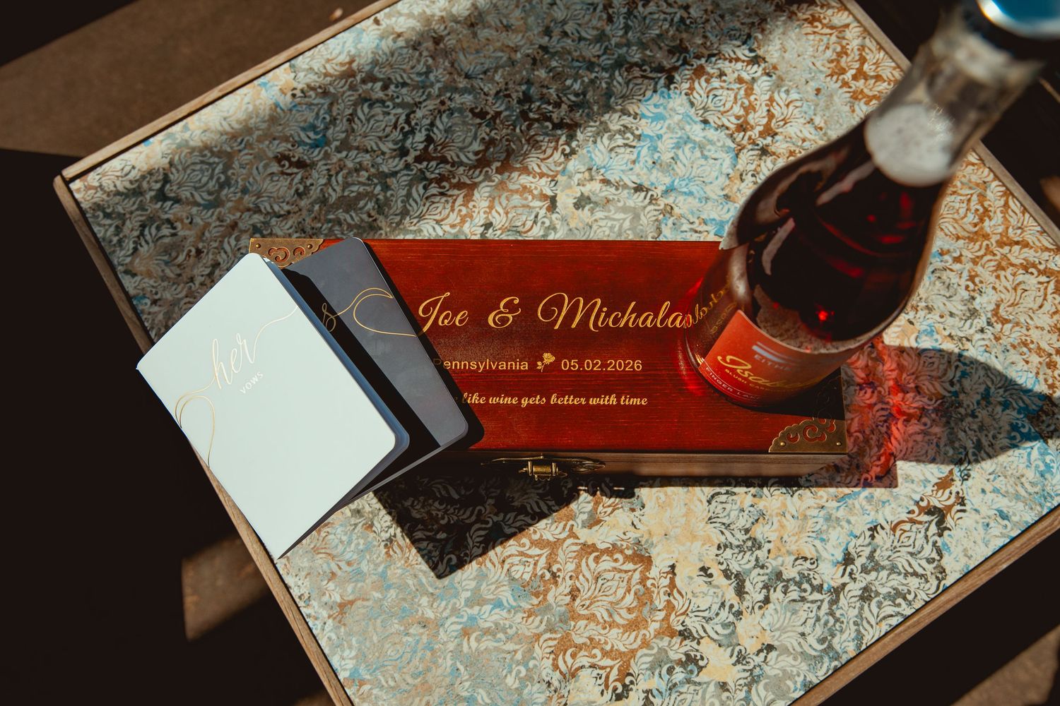 Wedding keepsake box for Joe & Mickalas with engraved names, date, and a wine bottle on a map table.