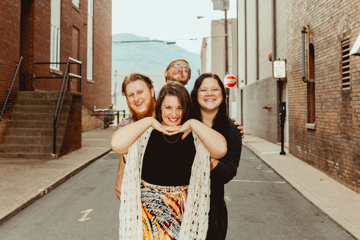 Candid group shots in a brick-lined city alley with natural lighting.