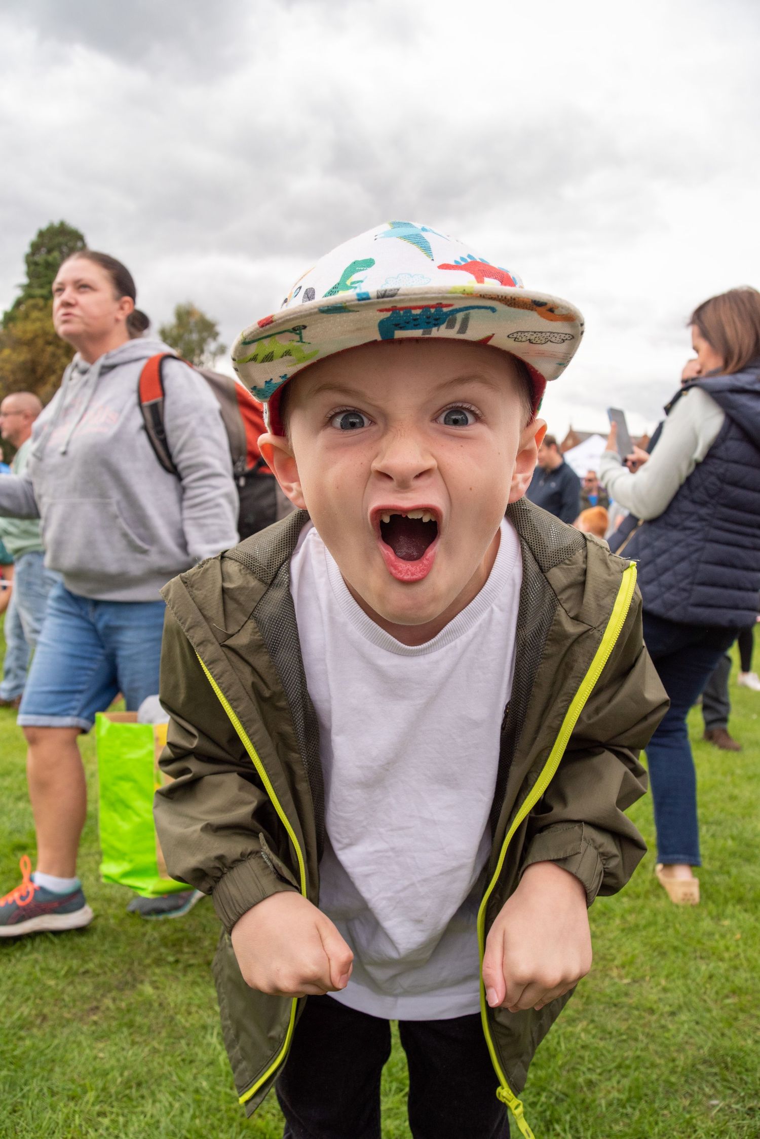 Animated child expressing excitement at outdoor community event.