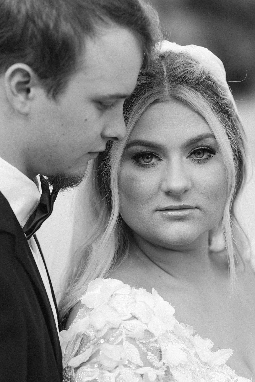 Intimate black and white close-up portrait of newlyweds sharing a tender moment.