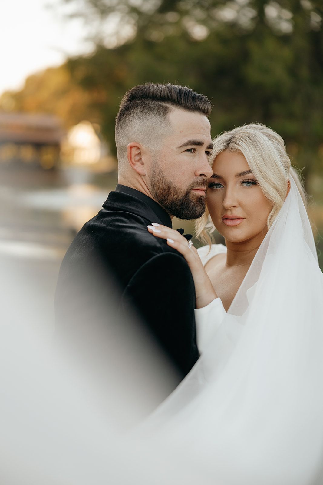 Intimate wedding portrait showing tender moment between newlyweds with soft focus.