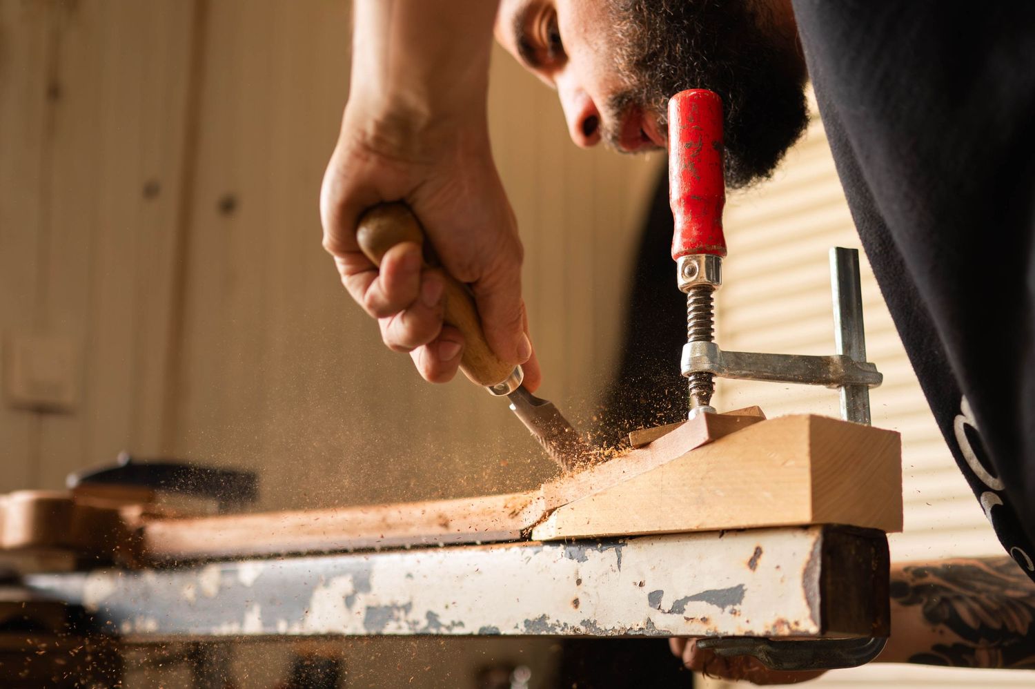 Close-up of hands making precise adjustments to an electric guitar neck.