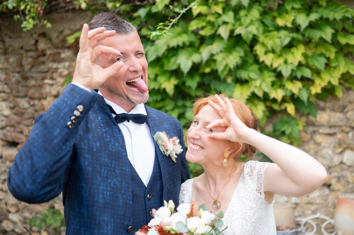 A couple shares joyful moments together in a garden setting wearing formal wedding attire.