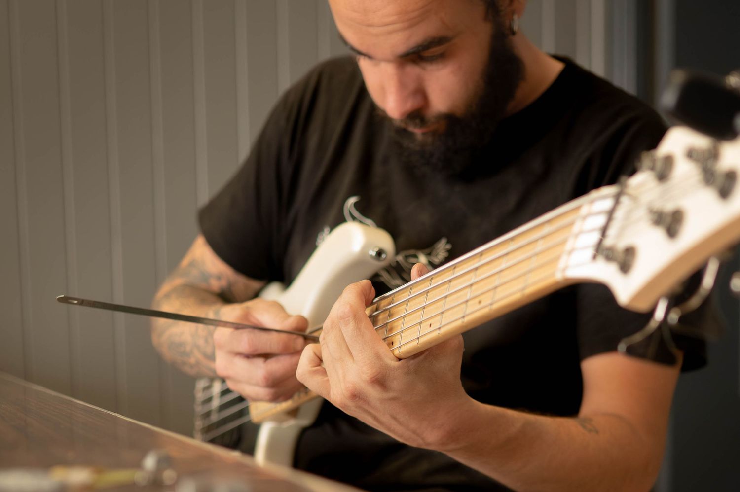 Musicians playing bass guitars in a dimly lit studio setting.