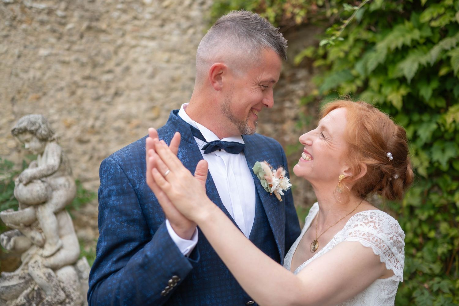 A happy couple shares a joyful moment together in a garden setting on their wedding day.