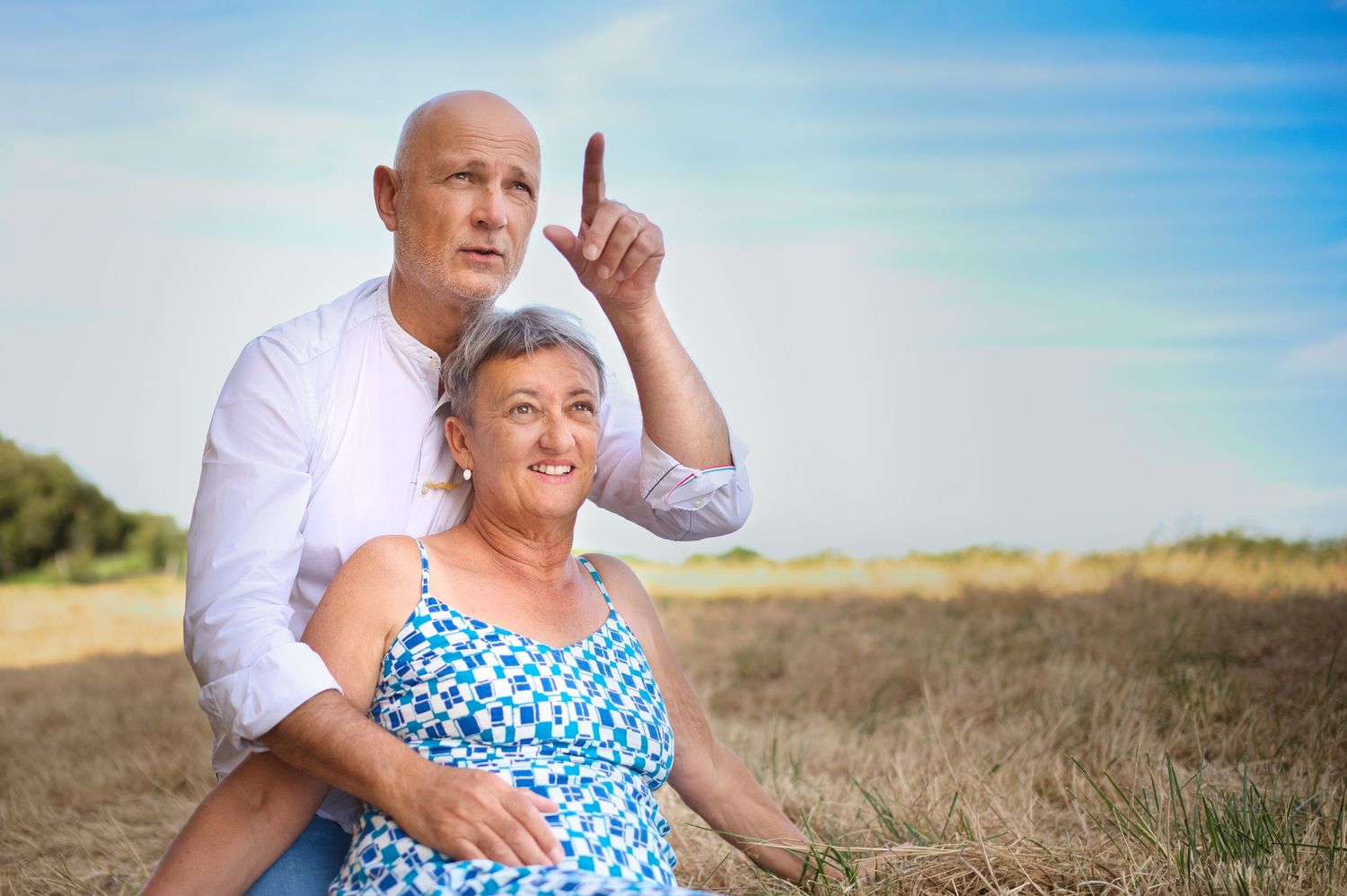 Happy couple enjoying outdoor photoshoot in blue and white summer outfits.