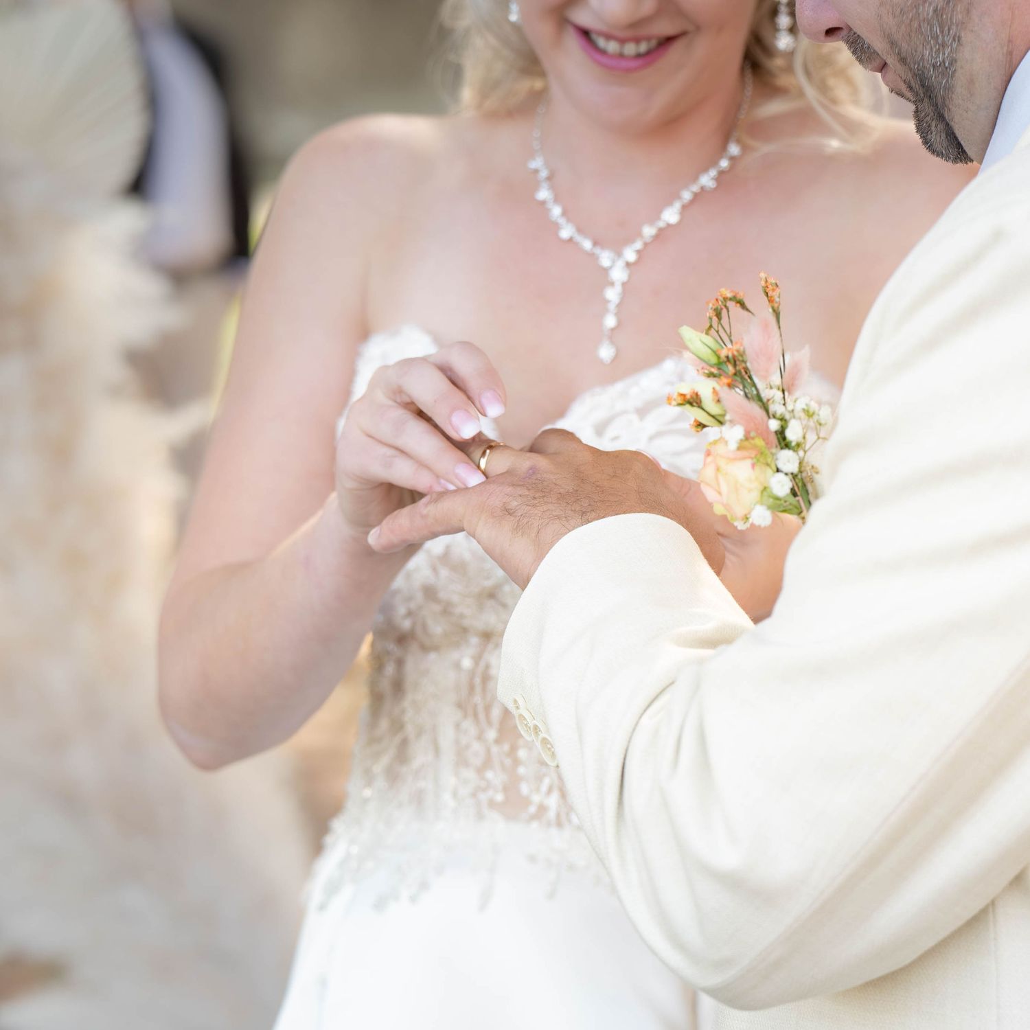 Close-up details of an elegant bride wearing pearl jewelry and a strapless wedding gown.