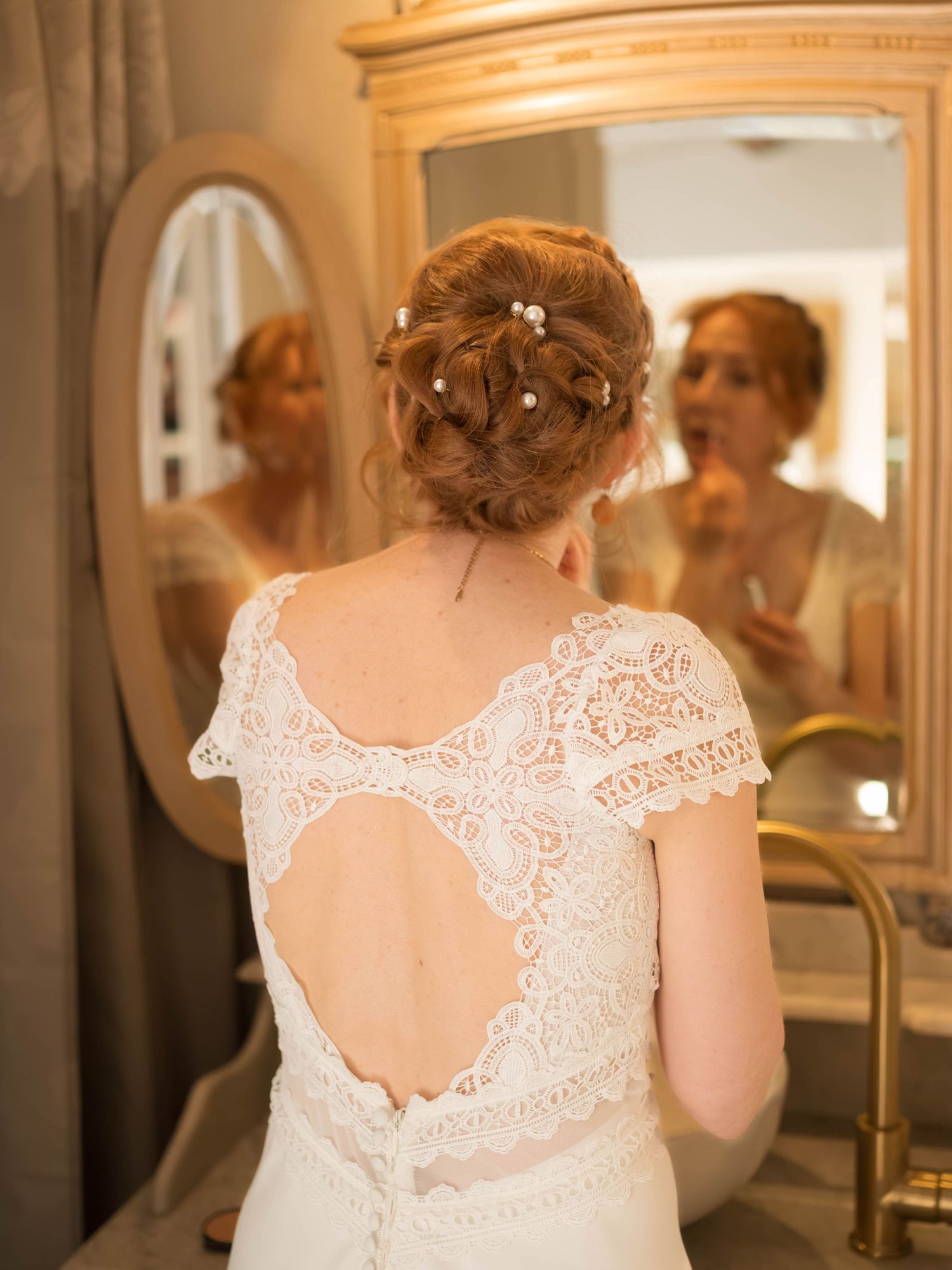 Back view of a wedding dress showing intricate lace detail and keyhole opening.
