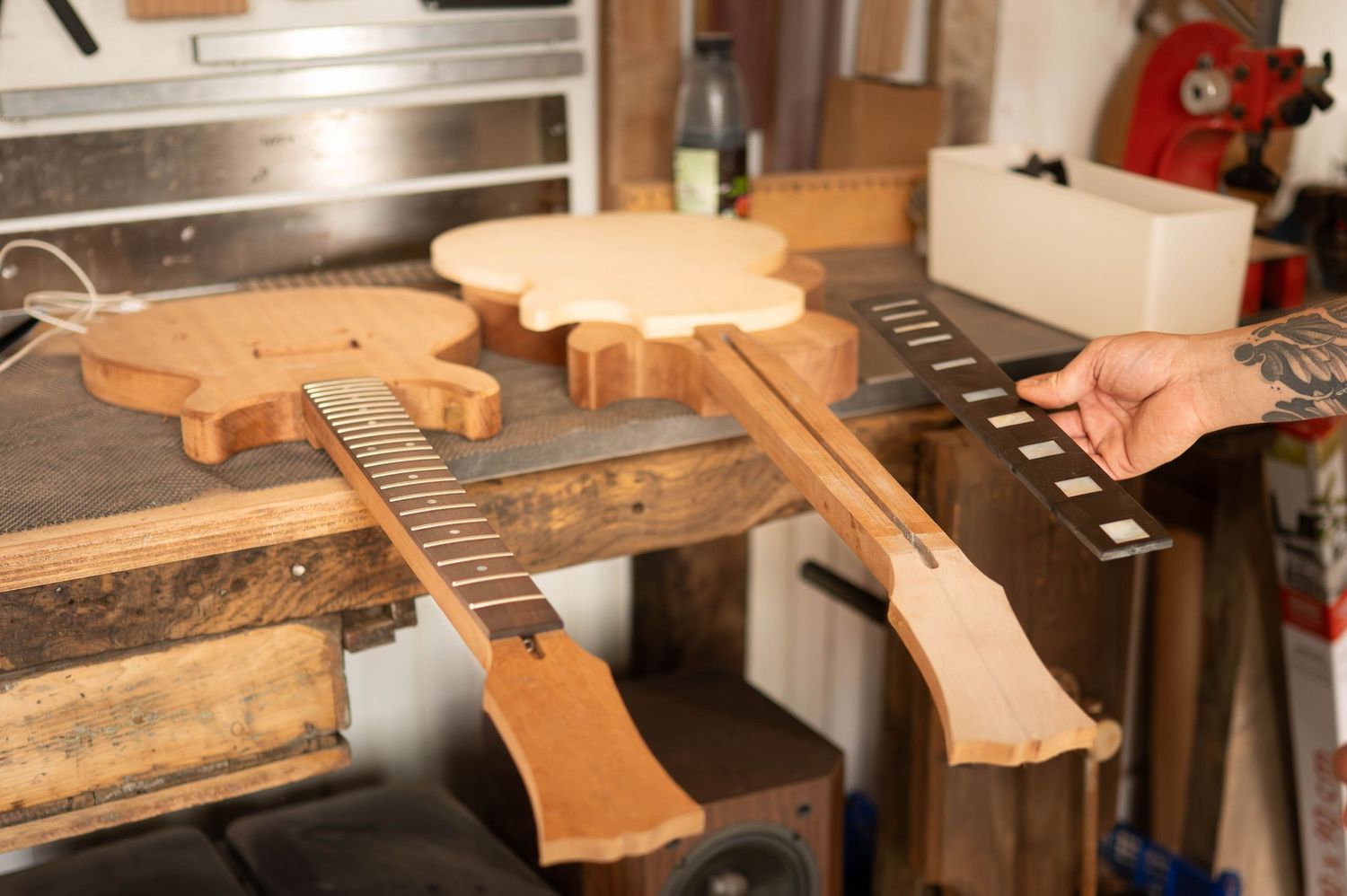 Detailed view of guitar neck repair and maintenance work being performed on a workbench.