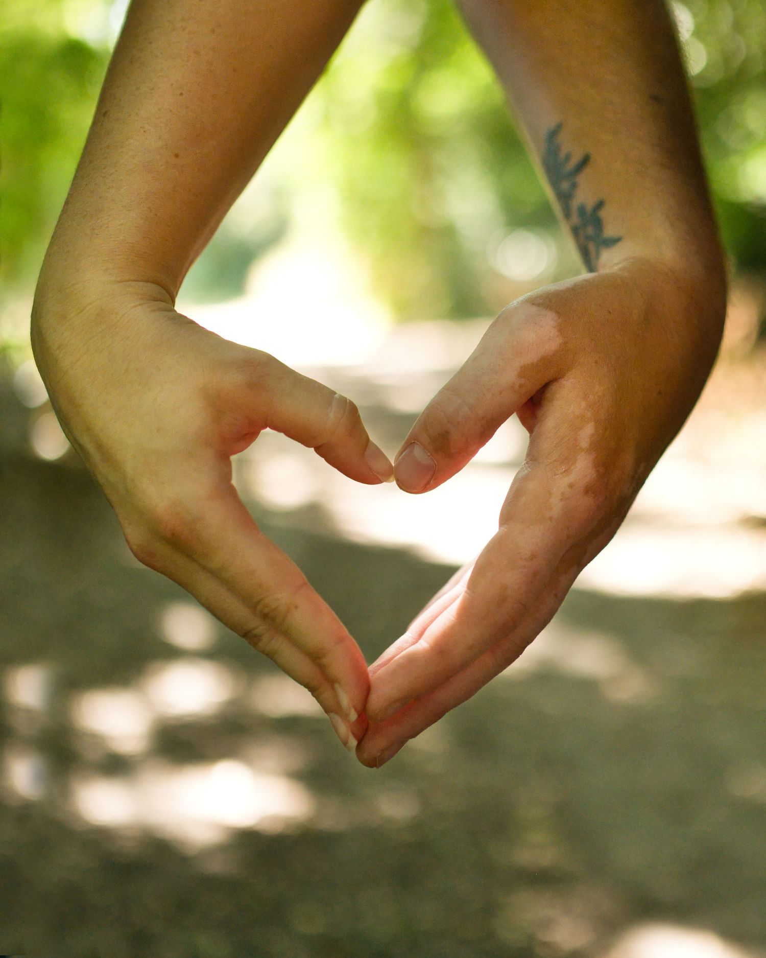 Hands gently touching in a soft natural lighting outdoors.