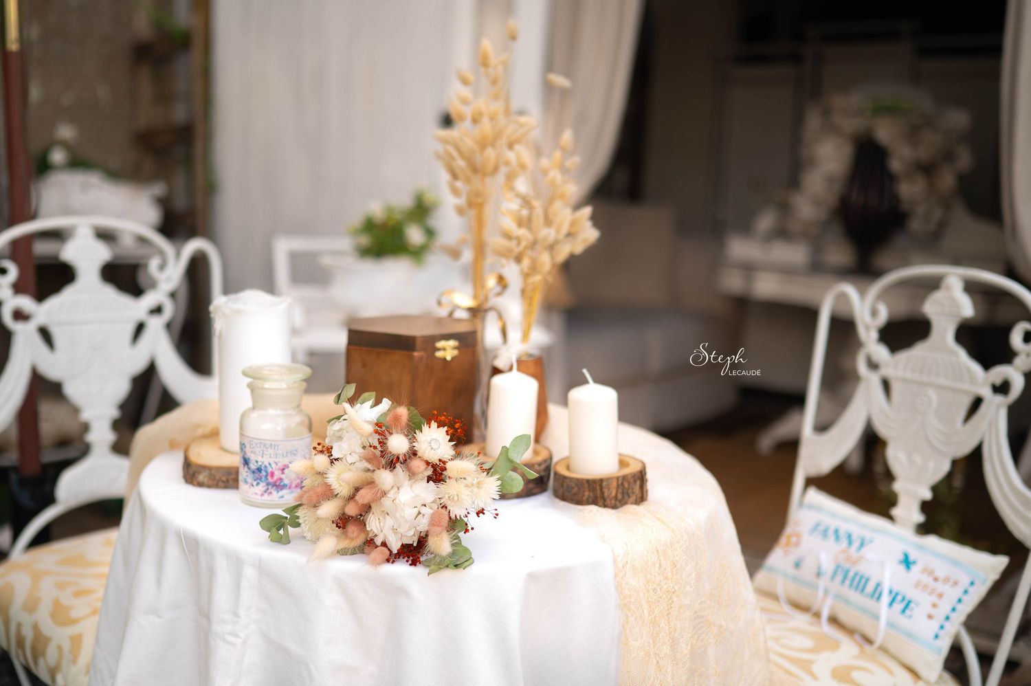 Elegant wedding reception table settings with white floral centerpieces and glowing candles in a romantic venue.
