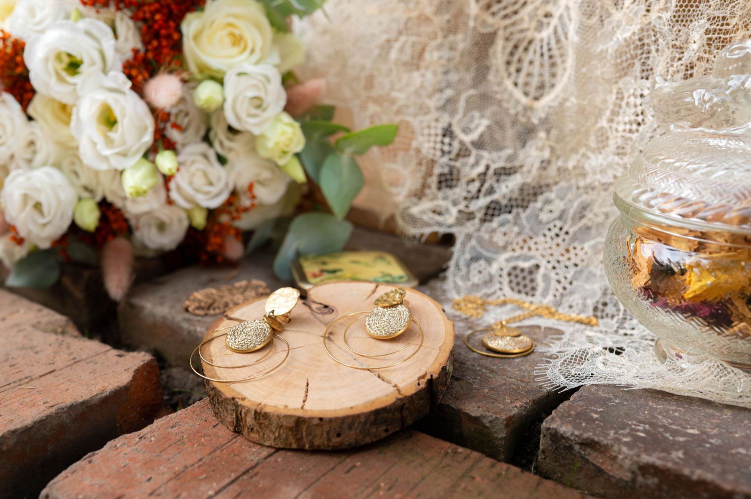 Vintage-style wedding decor with white roses, lace, and wooden elements.