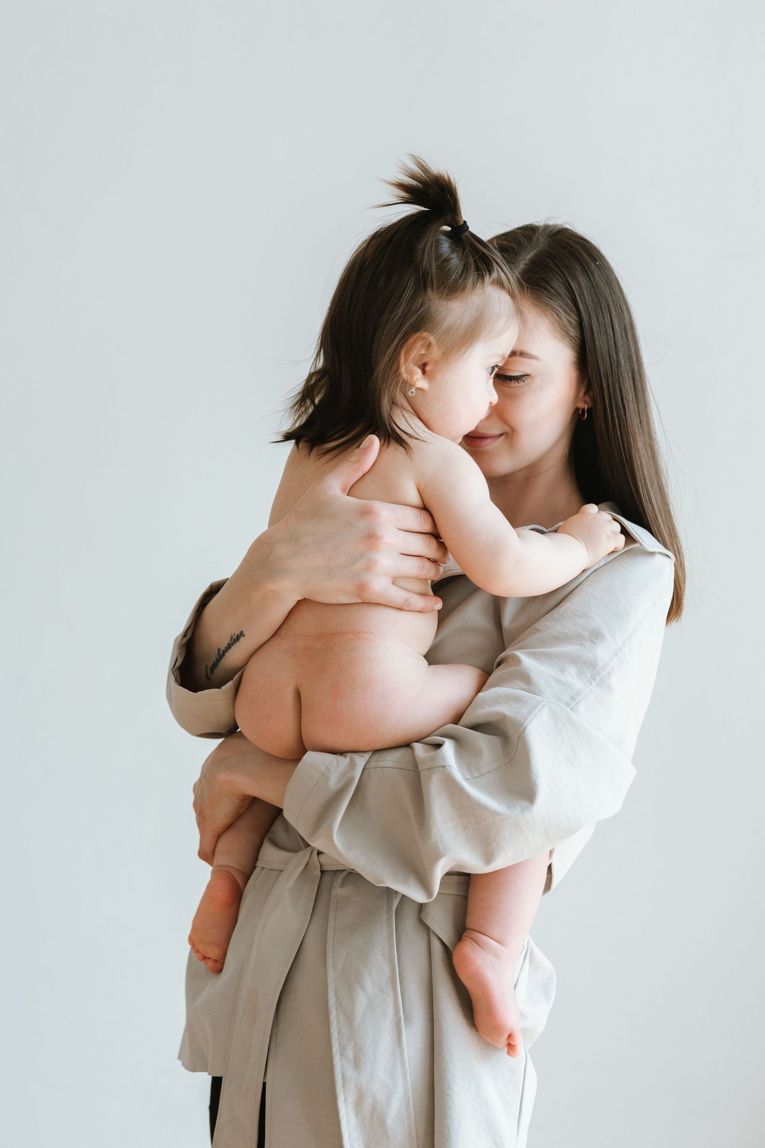 Tender moment captured in minimal portrait with soft neutral tones.