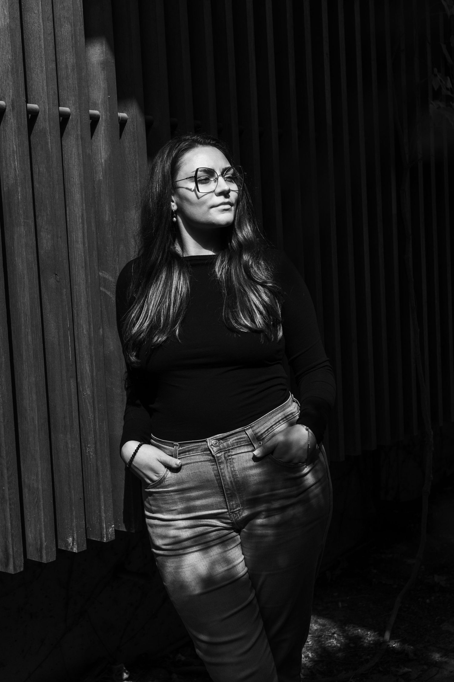 Black and white portrait with strong shadows and architectural elements.