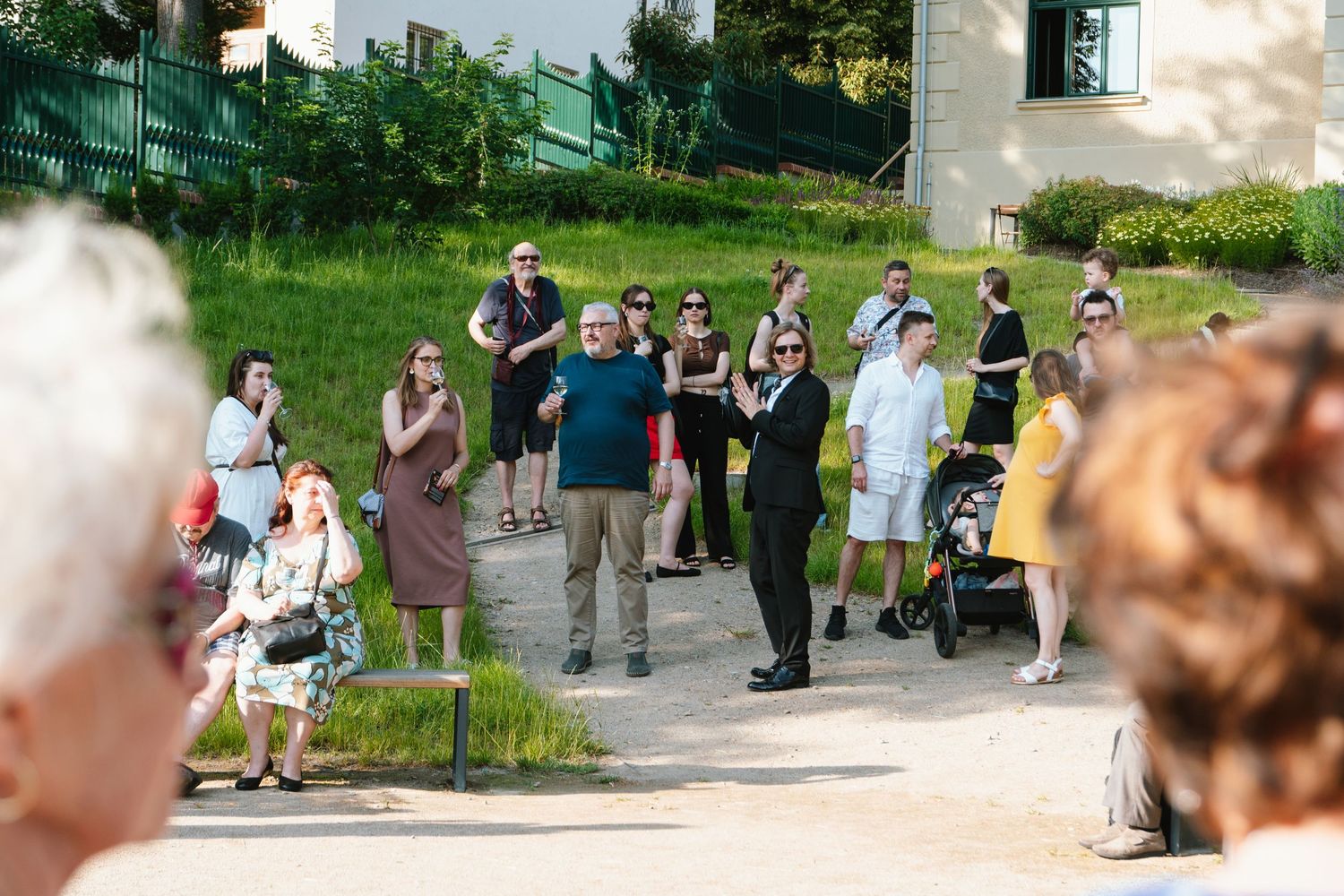 Crowd mingling at an outdoor community event on a sunny day.